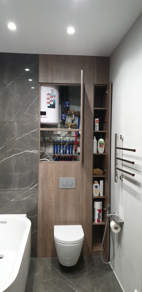 Small contemporary ensuite bathroom in Moscow with flat-panel cabinets, brown cabinets, a freestanding bath, a wall mounted toilet, black and white tiles, porcelain tiles, grey walls, porcelain flooring, grey floors, an enclosed toilet and wood walls.