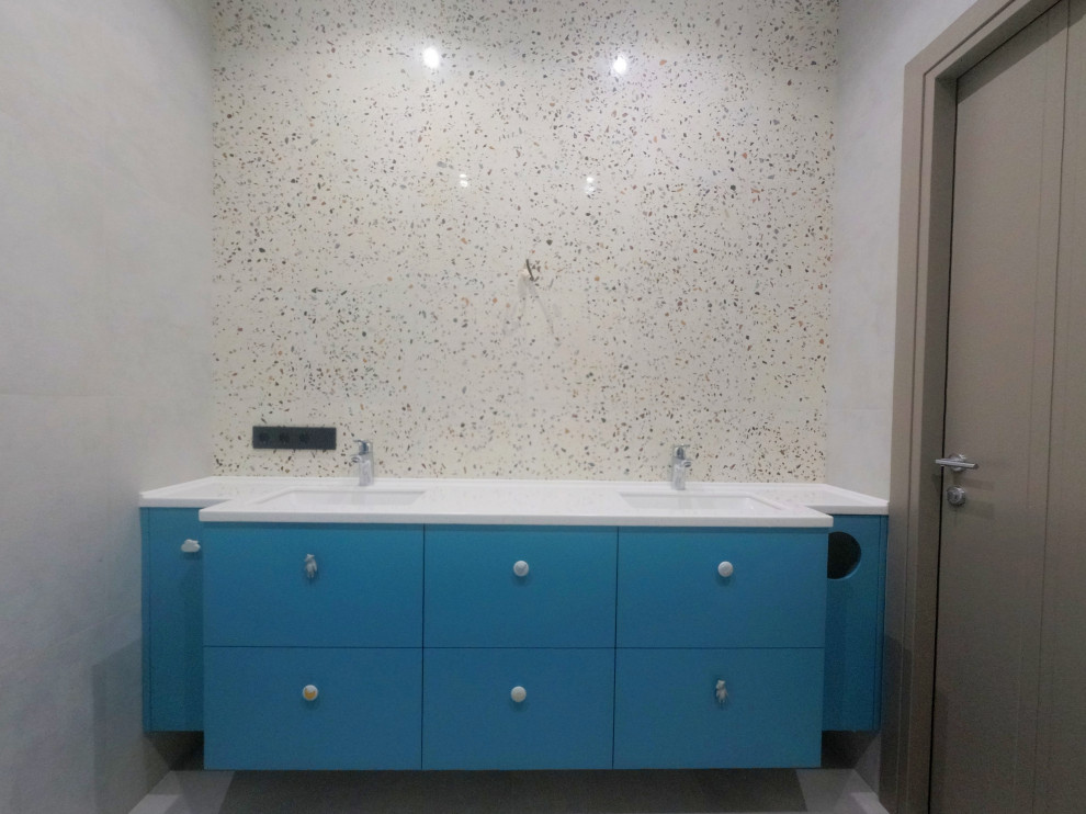 Inspiration for a medium sized contemporary bathroom in Moscow with flat-panel cabinets, turquoise cabinets, a wall mounted toilet, beige tiles, stone slabs, grey walls, porcelain flooring, a submerged sink, solid surface worktops, grey floors, a shower curtain, white worktops, an enclosed toilet, double sinks, a floating vanity unit and panelled walls.