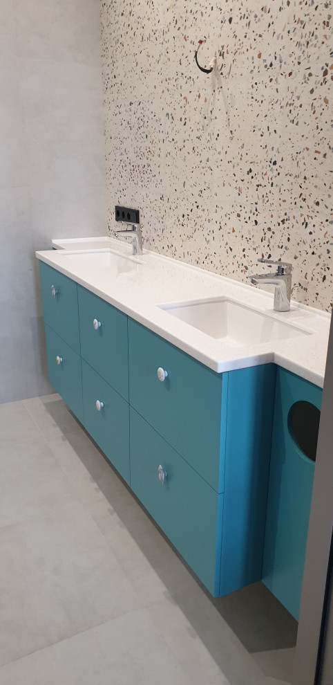 This is an example of a medium sized contemporary bathroom in Moscow with flat-panel cabinets, turquoise cabinets, a wall mounted toilet, beige tiles, stone slabs, grey walls, porcelain flooring, a submerged sink, solid surface worktops, grey floors, a shower curtain, white worktops, an enclosed toilet, double sinks, a floating vanity unit and panelled walls.