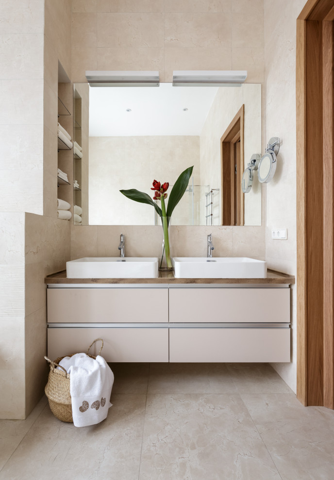 На фото: ванная комната в современном стиле с плоскими фасадами, бежевыми фасадами, бежевой плиткой, настольной раковиной, бежевым полом, коричневой столешницей и акцентной стеной с