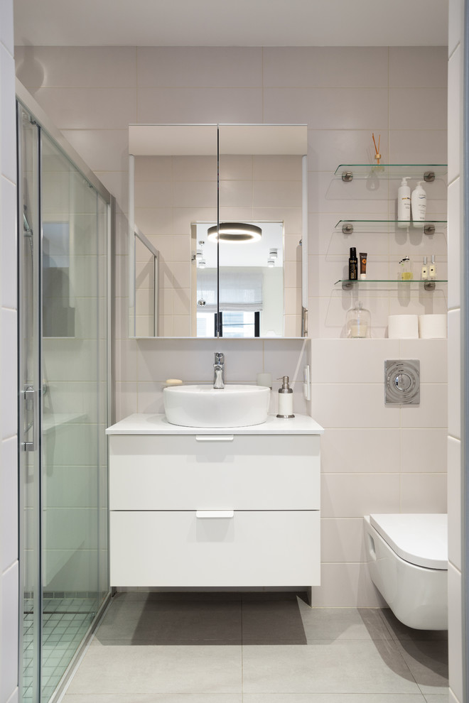 Стильный дизайн: маленькая ванная комната в современном стиле с плоскими фасадами, белыми фасадами, инсталляцией, белой плиткой, керамической плиткой, полом из керамогранита, душевой кабиной, столешницей из искусственного камня, серым полом, душем с раздвижными дверями, белой столешницей, душем в нише и настольной раковиной для на участке и в саду - последний тренд