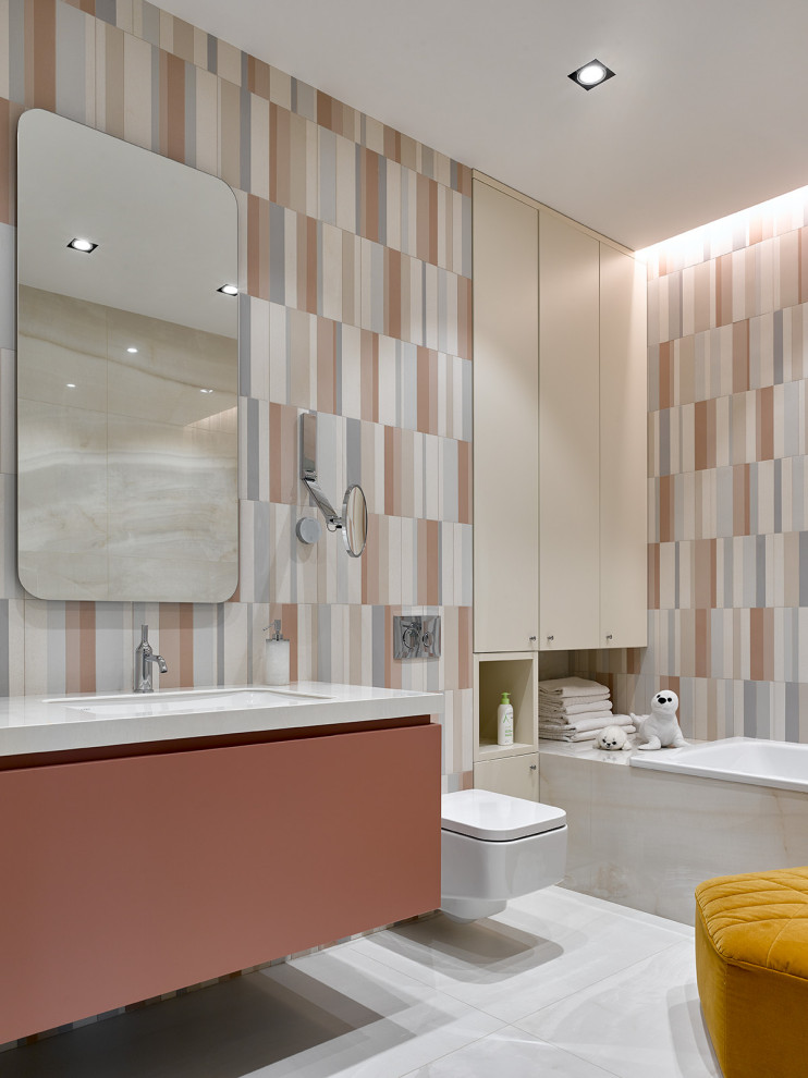 This is an example of a large contemporary ensuite bathroom in Moscow with flat-panel cabinets, a built-in bath, a wall mounted toilet, multi-coloured tiles, a submerged sink, white floors, white worktops, a single sink, a floating vanity unit and an enclosed toilet.