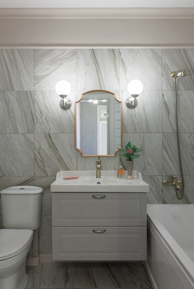 Inspiration for a small traditional ensuite bathroom in Other with recessed-panel cabinets, grey cabinets, an alcove bath, a two-piece toilet, beige tiles, porcelain tiles, beige walls, porcelain flooring, a built-in sink and beige floors.