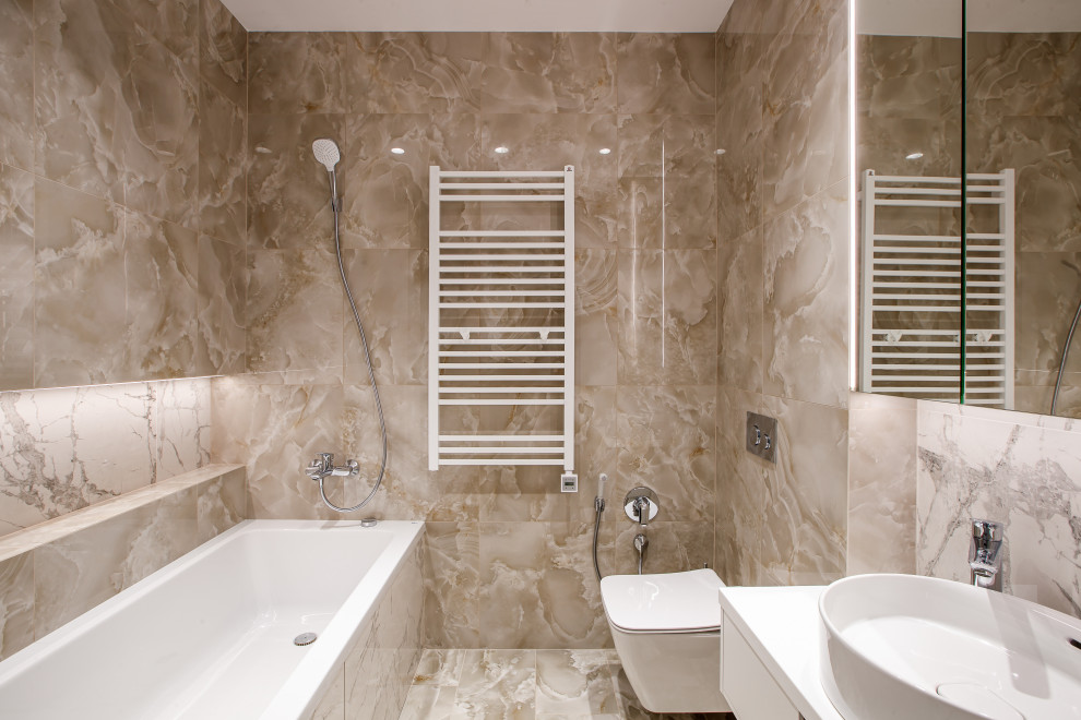 Inspiration för ett mellanstort funkis vit vitt en-suite badrum, med ett badkar i en alkov, ett fristående handfat, beiget golv, släta luckor, vita skåp, en vägghängd toalettstol och beige kakel