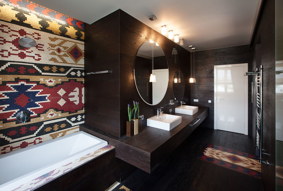 Cette image montre une salle de bain principale sud-ouest américain avec une vasque, un plan de toilette en bois, une baignoire posée, un combiné douche/baignoire et un carrelage multicolore.