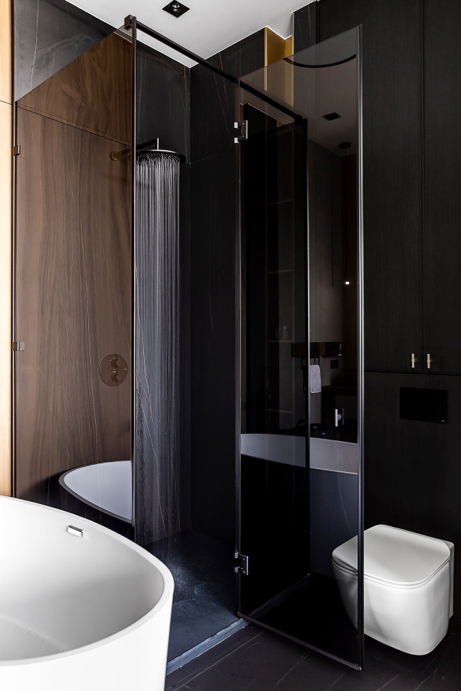 Пример оригинального дизайна: совмещенный санузел в современном стиле с отдельно стоящей ванной, черным полом, угловым душем, инсталляцией, душевой кабиной и душем с распашными дверями
