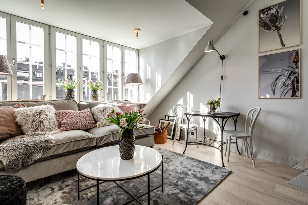 Offenes Skandinavisches Wohnzimmer ohne Kamin mit grauer Wandfarbe, hellem Holzboden und beigem Boden in Stockholm