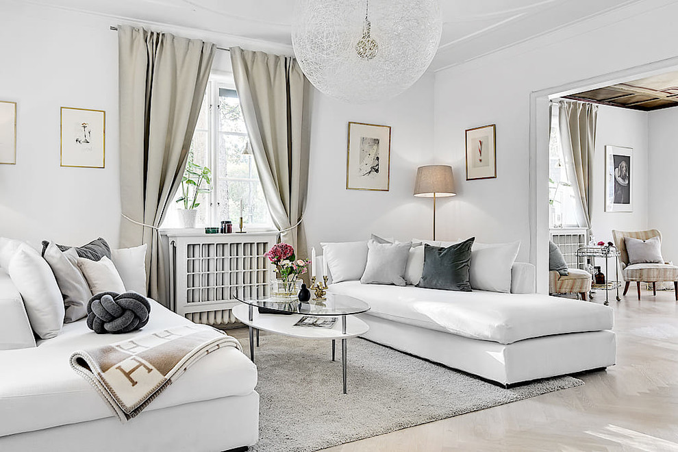 Photo of a scandinavian enclosed living room in Stockholm with white walls and beige floors.