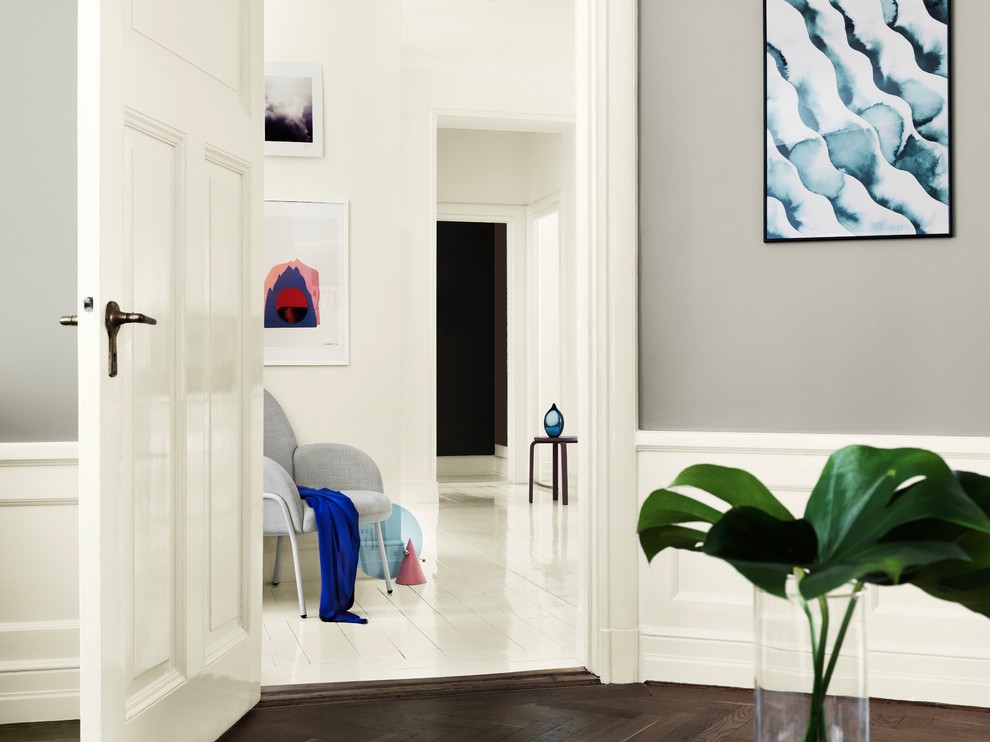Inredning av ett minimalistiskt separat vardagsrum, med grå väggar och mellanmörkt trägolv