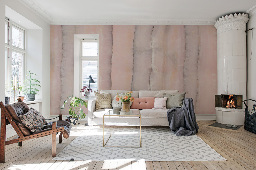 ヨーテボリにある北欧スタイルのおしゃれなリビング (ピンクの壁、淡色無垢フローリング、コーナー設置型暖炉、石材の暖炉まわり、ベージュの床) の写真