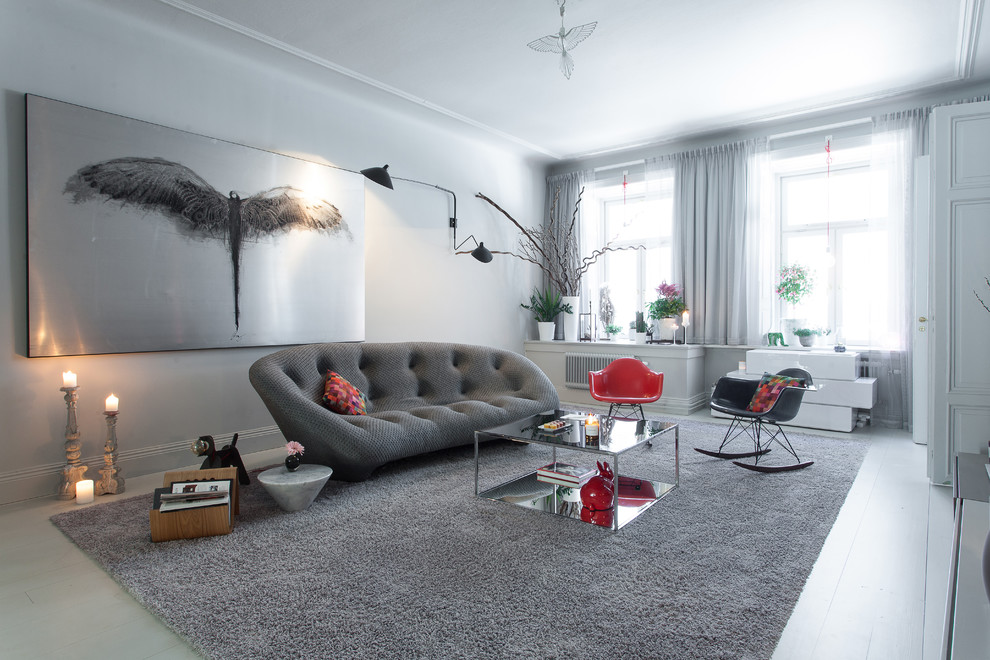 This is an example of a large scandinavian open plan living room in Stockholm with white walls, painted wood flooring, no fireplace and no tv.