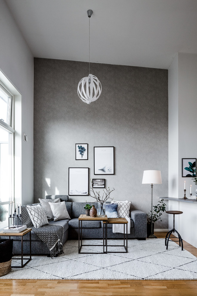 Inspiration for a mid-sized scandinavian formal and open concept light wood floor living room remodel in Gothenburg with gray walls and no tv