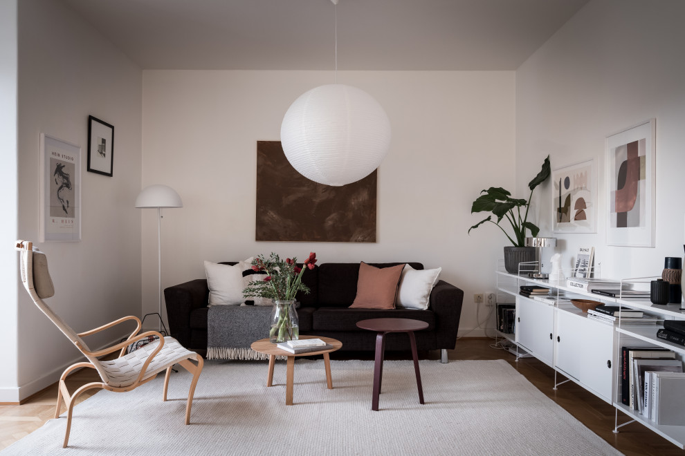 Inspiration for a medium sized scandinavian living room in Gothenburg with white walls, medium hardwood flooring, no tv and brown floors.