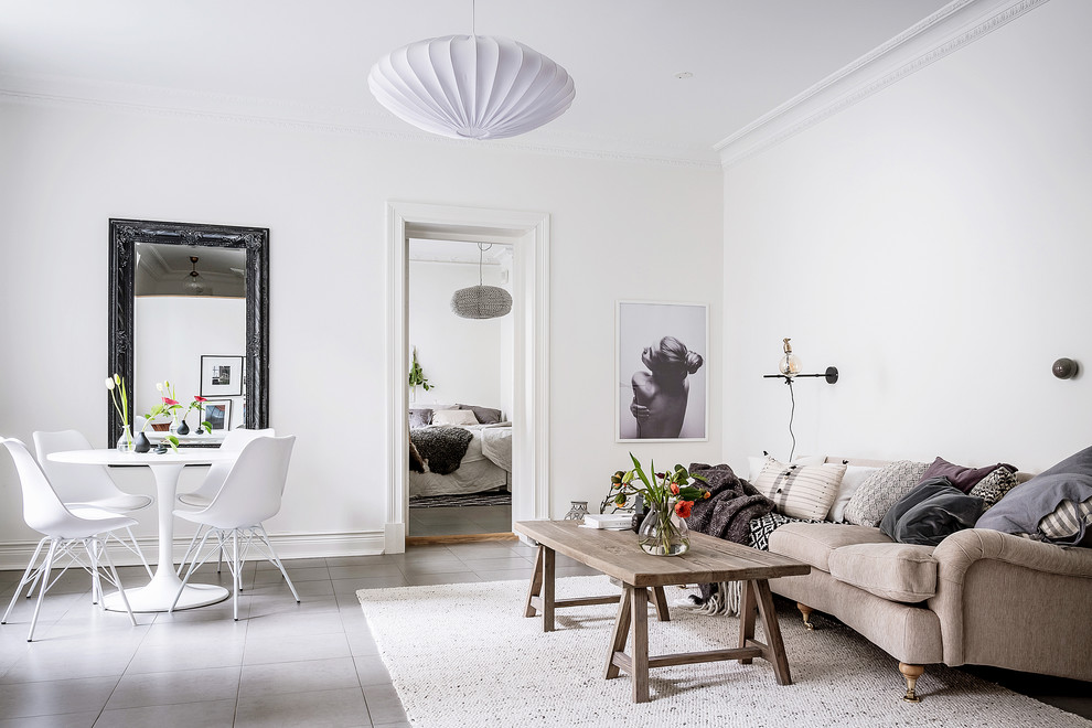 Inspiration för minimalistiska allrum med öppen planlösning, med vita väggar och grått golv