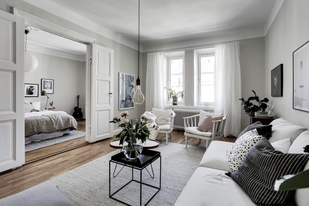 Mittelgroßes Klassisches Wohnzimmer mit weißer Wandfarbe, braunem Holzboden und buntem Boden in Göteborg