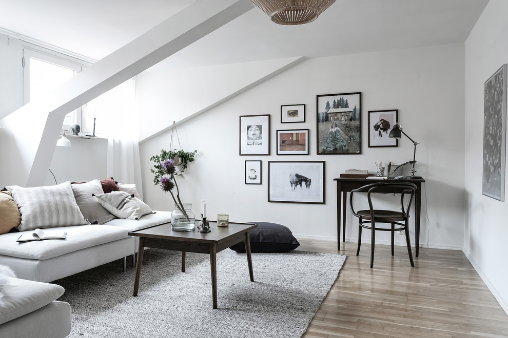 Fernseherloses, Abgetrenntes Nordisches Wohnzimmer ohne Kamin mit weißer Wandfarbe und braunem Holzboden in Göteborg