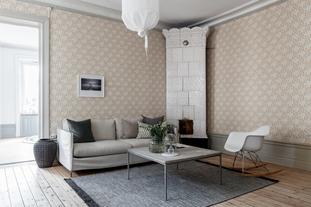 Medium sized scandinavian living room in Stockholm with multi-coloured walls, light hardwood flooring, a corner fireplace and beige floors.