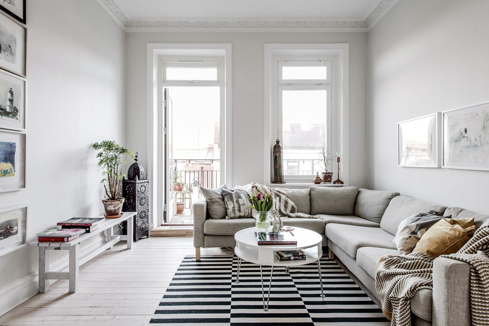 Cette photo montre un salon scandinave de taille moyenne et fermé avec un mur blanc, parquet clair et un sol beige.