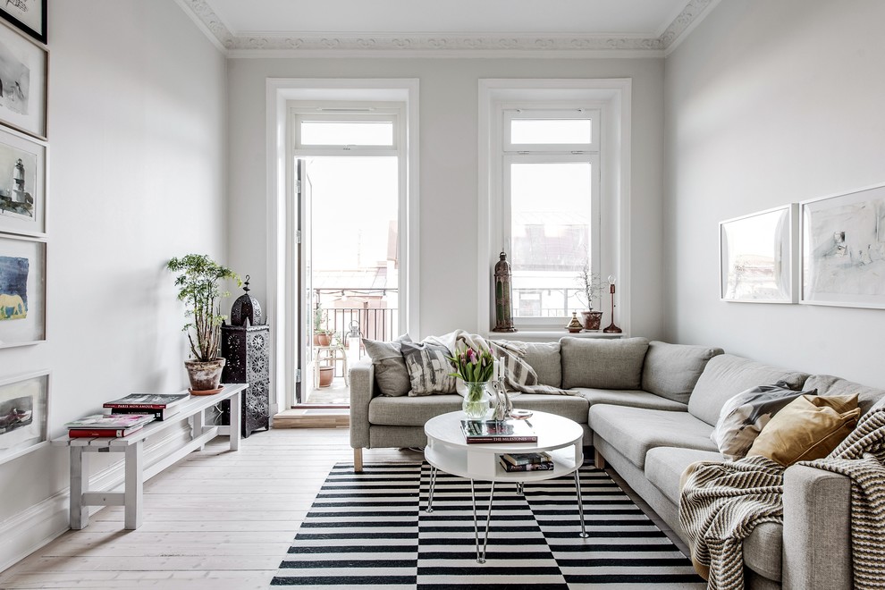 Inspiration for a mid-sized scandinavian enclosed light wood floor and beige floor living room remodel in Gothenburg with white walls