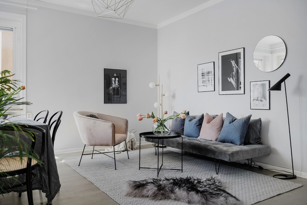 Kleines, Offenes Nordisches Wohnzimmer mit hellem Holzboden und grauer Wandfarbe in Stockholm