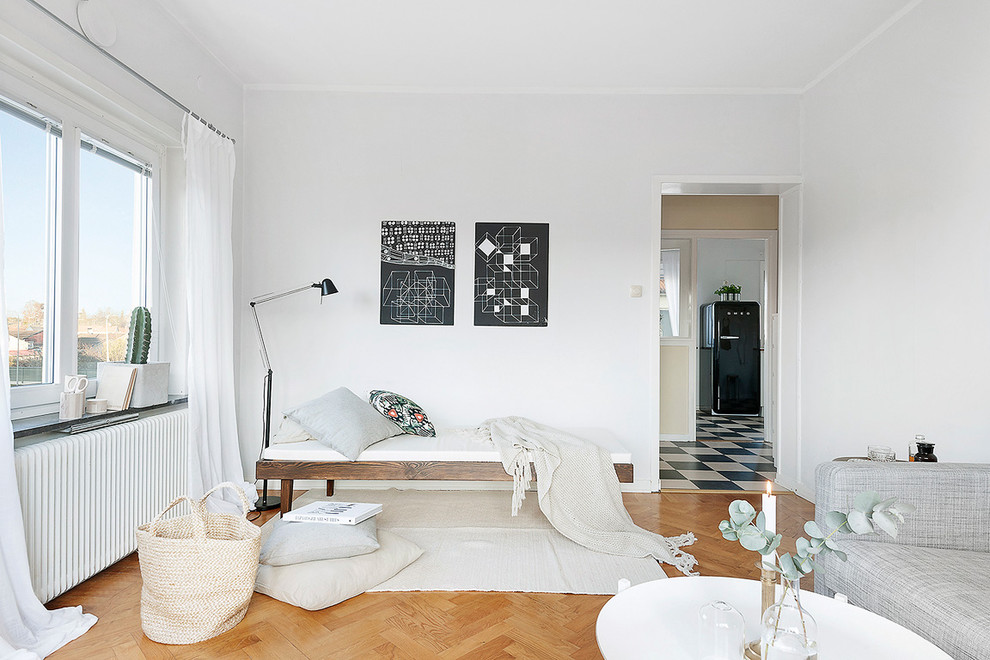 На фото: открытая гостиная комната среднего размера в скандинавском стиле с белыми стенами и паркетным полом среднего тона без камина, телевизора