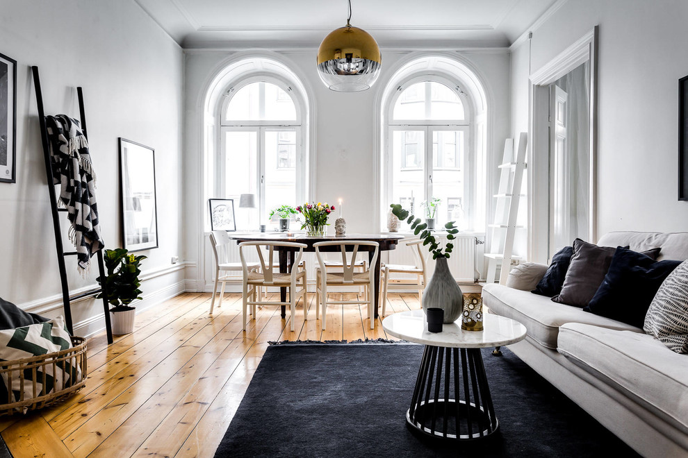 Medium sized scandi open plan living room in Stockholm with white walls, light hardwood flooring and no tv.