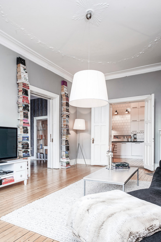 Источник вдохновения для домашнего уюта: большая парадная, открытая гостиная комната в скандинавском стиле с серыми стенами, светлым паркетным полом и отдельно стоящим телевизором