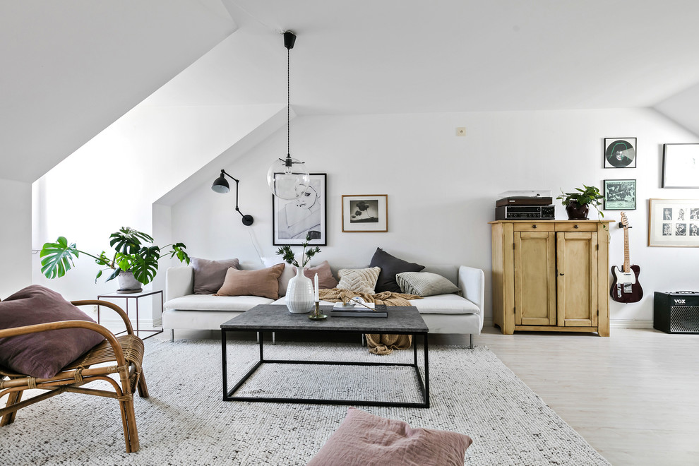 На фото: гостиная комната в скандинавском стиле с музыкальной комнатой и белыми стенами с