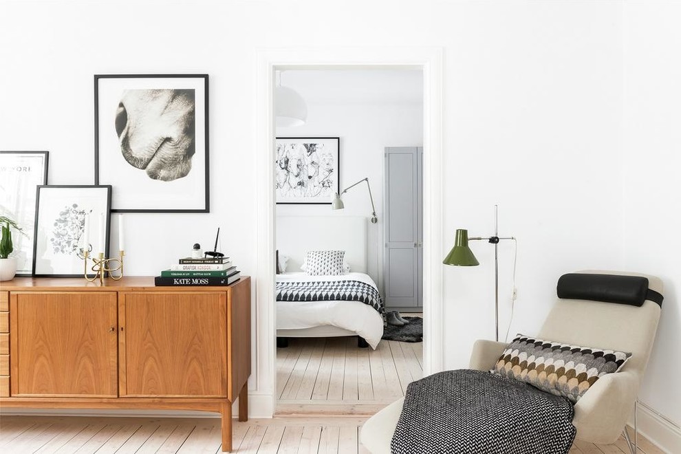 Ejemplo de salón para visitas cerrado escandinavo de tamaño medio sin televisor con suelo de madera clara y paredes blancas