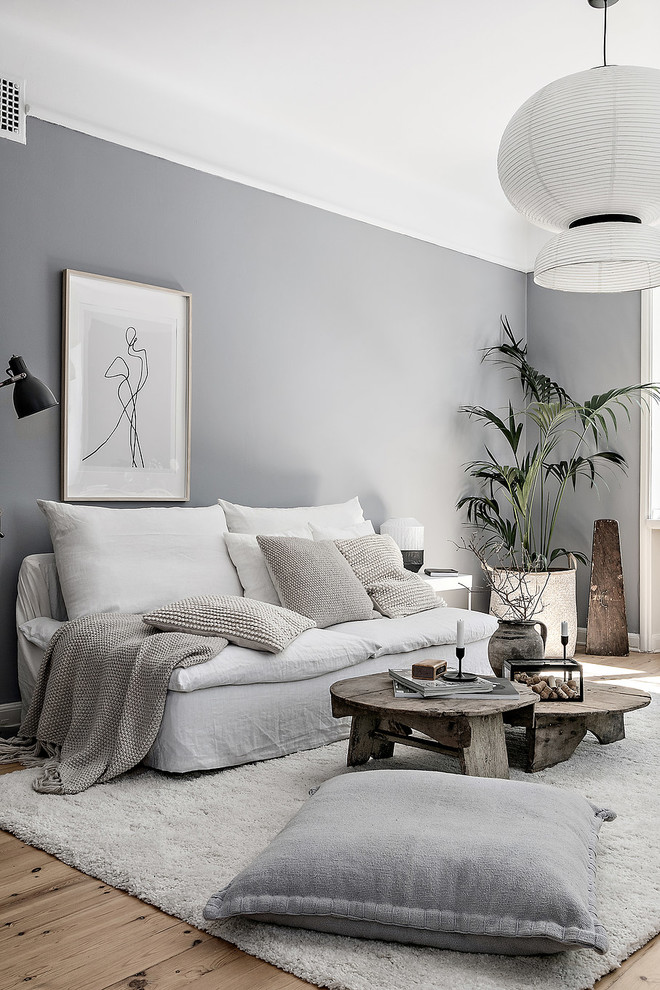 Design ideas for a medium sized scandi living room in Stockholm with grey walls, no fireplace and light hardwood flooring.