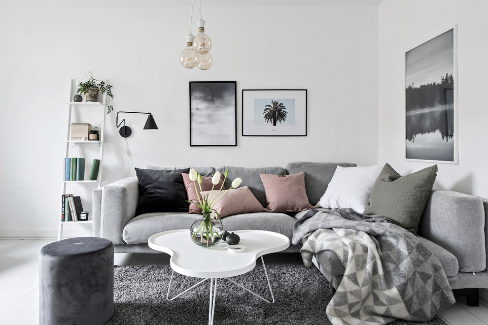 Mittelgroßes Skandinavisches Wohnzimmer mit grauer Wandfarbe, gebeiztem Holzboden und gelbem Boden in Göteborg