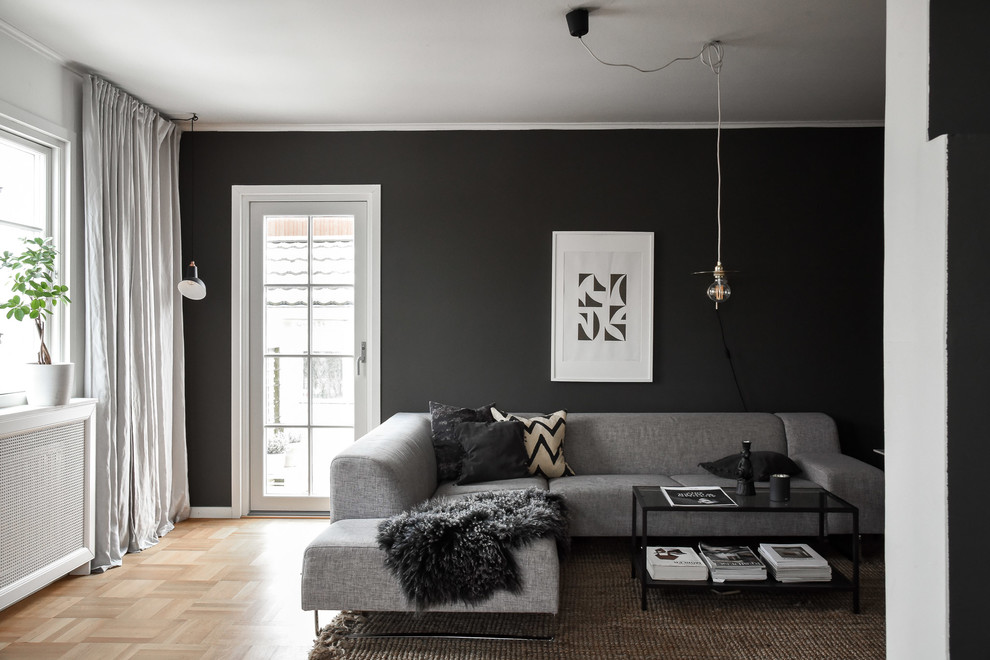 Living room - small scandinavian enclosed light wood floor and beige floor living room idea in Gothenburg with black walls