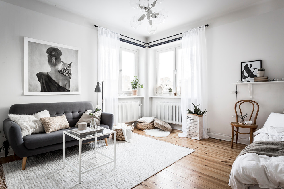 Foto de salón para visitas abierto nórdico de tamaño medio sin televisor con paredes blancas y suelo de madera en tonos medios