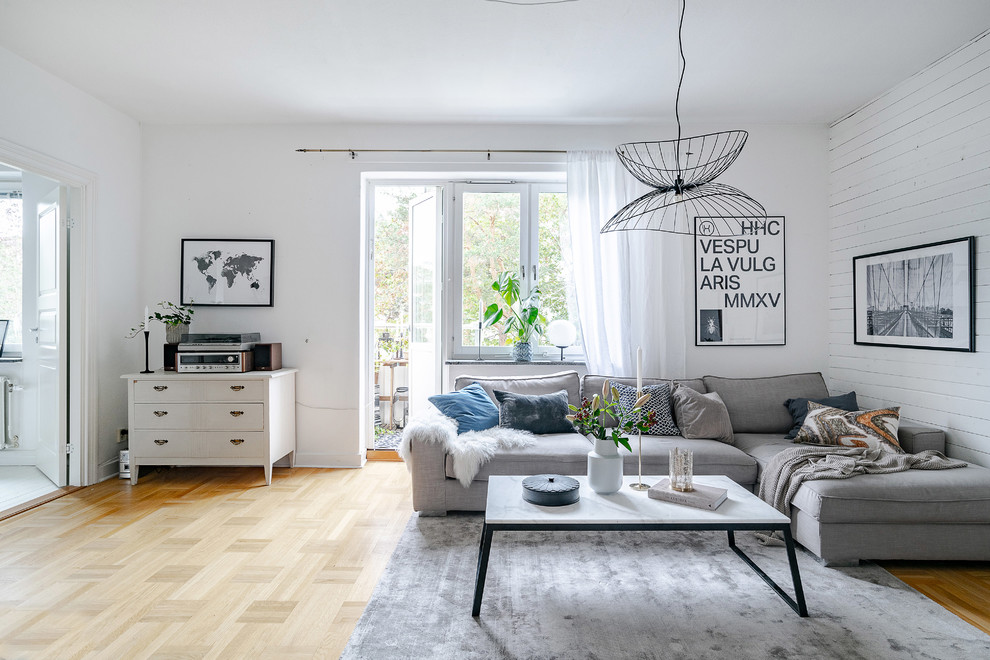 Immagine di un soggiorno scandinavo chiuso con pareti bianche, pavimento in legno massello medio e pavimento marrone