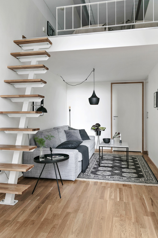 Свежая идея для дизайна: маленькая двухуровневая гостиная комната в скандинавском стиле с белыми стенами, паркетным полом среднего тона и бежевым полом для на участке и в саду - отличное фото интерьера