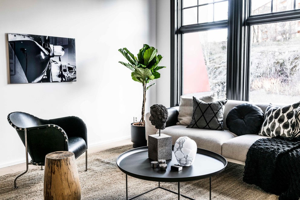 Danish light wood floor and brown floor living room photo in Stockholm with white walls