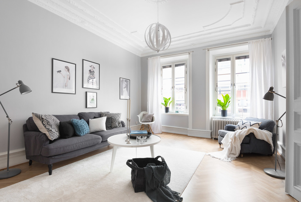 Idéer för att renovera ett stort minimalistiskt separat vardagsrum, med grå väggar, ljust trägolv och brunt golv