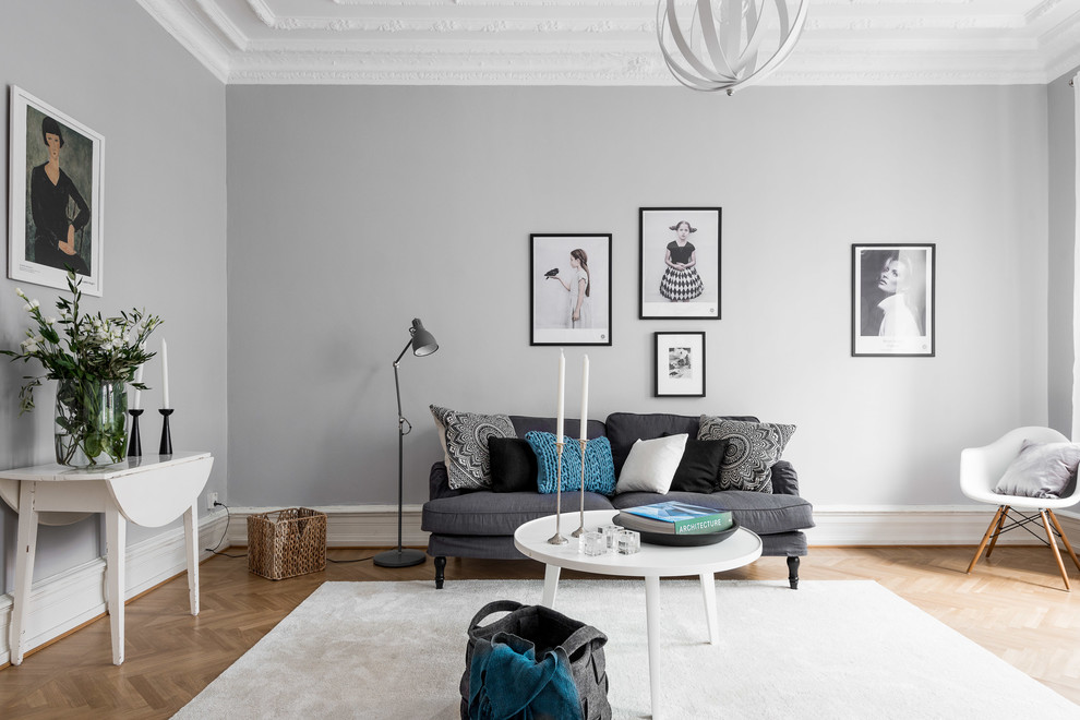 Ispirazione per un soggiorno scandinavo di medie dimensioni e chiuso con pareti grigie, parquet chiaro, nessun camino, nessuna TV e pavimento marrone
