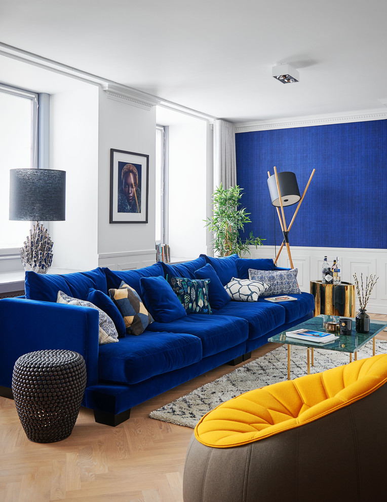 Идея дизайна: парадная, открытая гостиная комната среднего размера в современном стиле с синими стенами, светлым паркетным полом, бежевым полом и синим диваном без камина