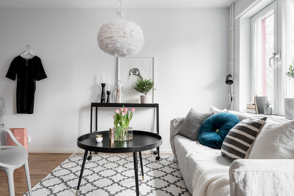 Kleines, Fernseherloses, Offenes Nordisches Wohnzimmer ohne Kamin mit weißer Wandfarbe und braunem Holzboden in Göteborg
