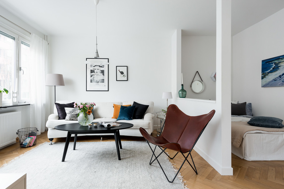 Imagen de salón abierto nórdico pequeño sin chimenea con paredes blancas y suelo de madera en tonos medios