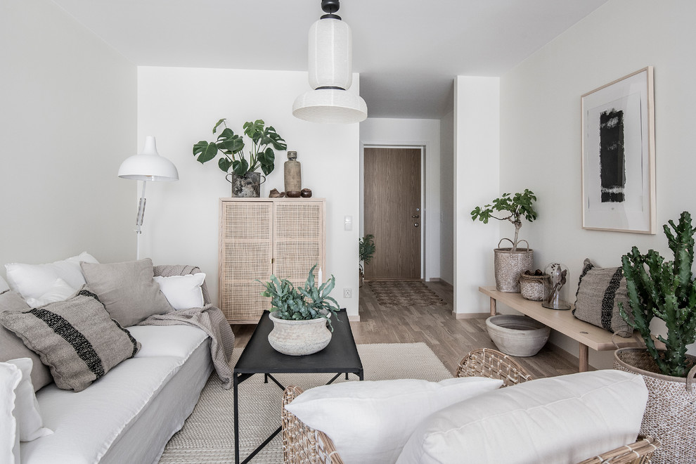 Diseño de salón nórdico con paredes blancas, suelo de madera clara y suelo marrón