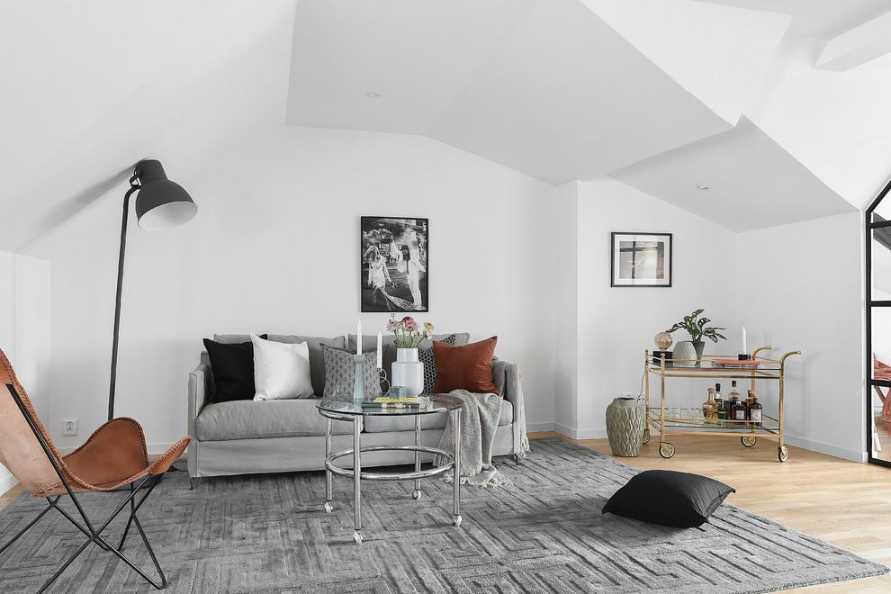 Mittelgroßes, Fernseherloses, Offenes Skandinavisches Wohnzimmer ohne Kamin mit hellem Holzboden, Hausbar und weißer Wandfarbe in Stockholm
