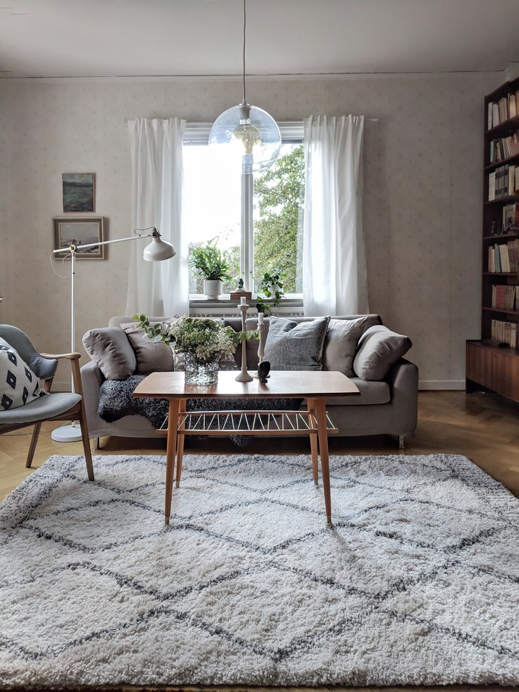 Design ideas for a scandinavian living room in Stockholm with a reading nook, medium hardwood flooring and brown floors.