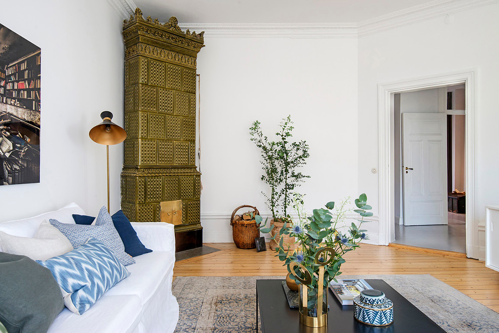 Mittelgroßes, Repräsentatives, Fernseherloses, Offenes Nordisches Wohnzimmer ohne Kamin mit weißer Wandfarbe und braunem Holzboden in Stockholm