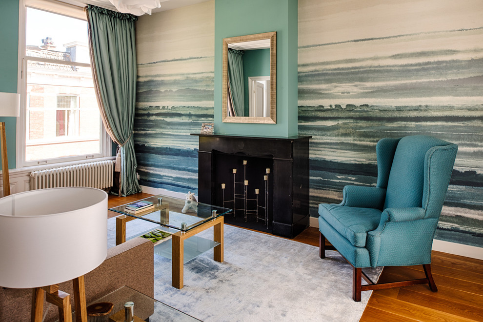 Inspiration pour un salon nordique avec une salle de réception, un mur multicolore, un sol en bois brun, une cheminée standard et aucun téléviseur.