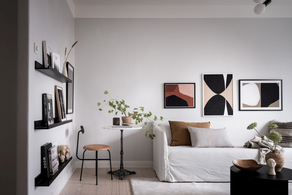Inredning av ett minimalistiskt mellanstort allrum med öppen planlösning, med grå väggar och beiget golv