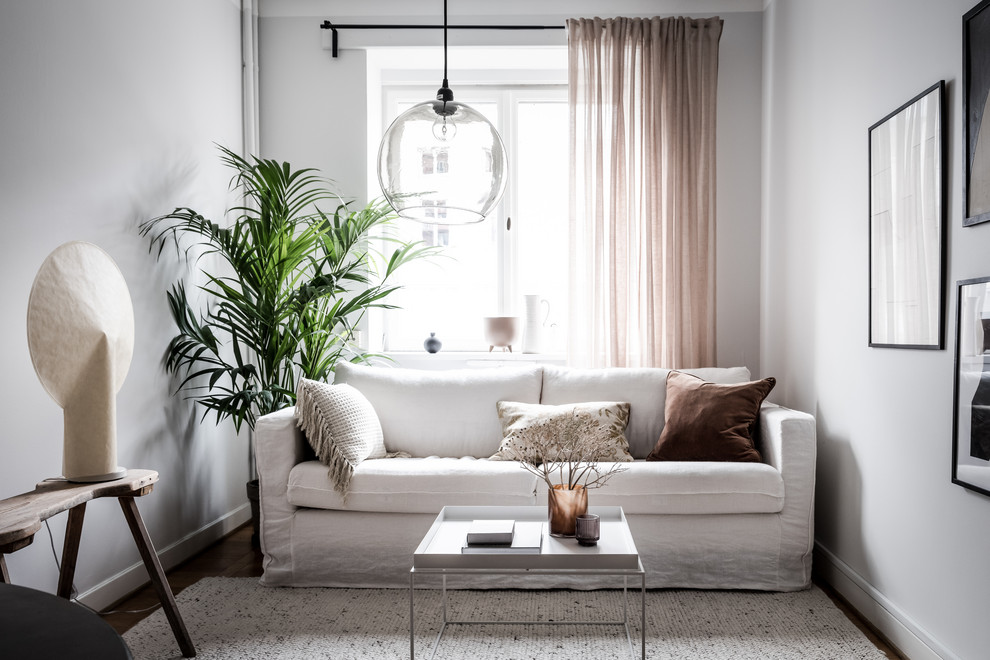 Bild på ett mellanstort minimalistiskt vardagsrum, med vita väggar och brunt golv