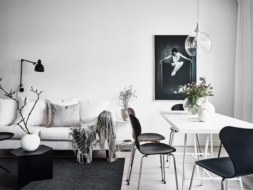Living room - scandinavian light wood floor living room idea in Gothenburg with white walls
