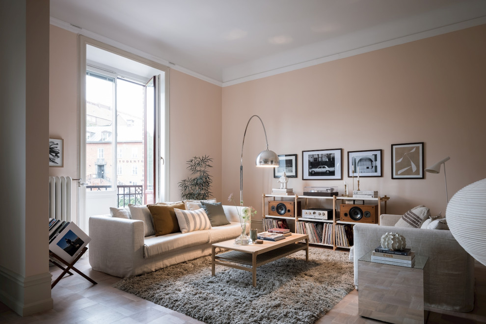 Стильный дизайн: изолированная гостиная комната в скандинавском стиле с розовыми стенами, темным паркетным полом и коричневым полом - последний тренд